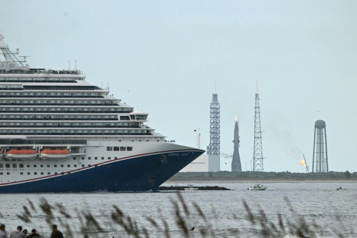 A cruise ship sails by Blue Origin's New Glenn rocket, which has scrubbed its launch for weather issues at the Space Force Station in Cape Canaveral, Florida