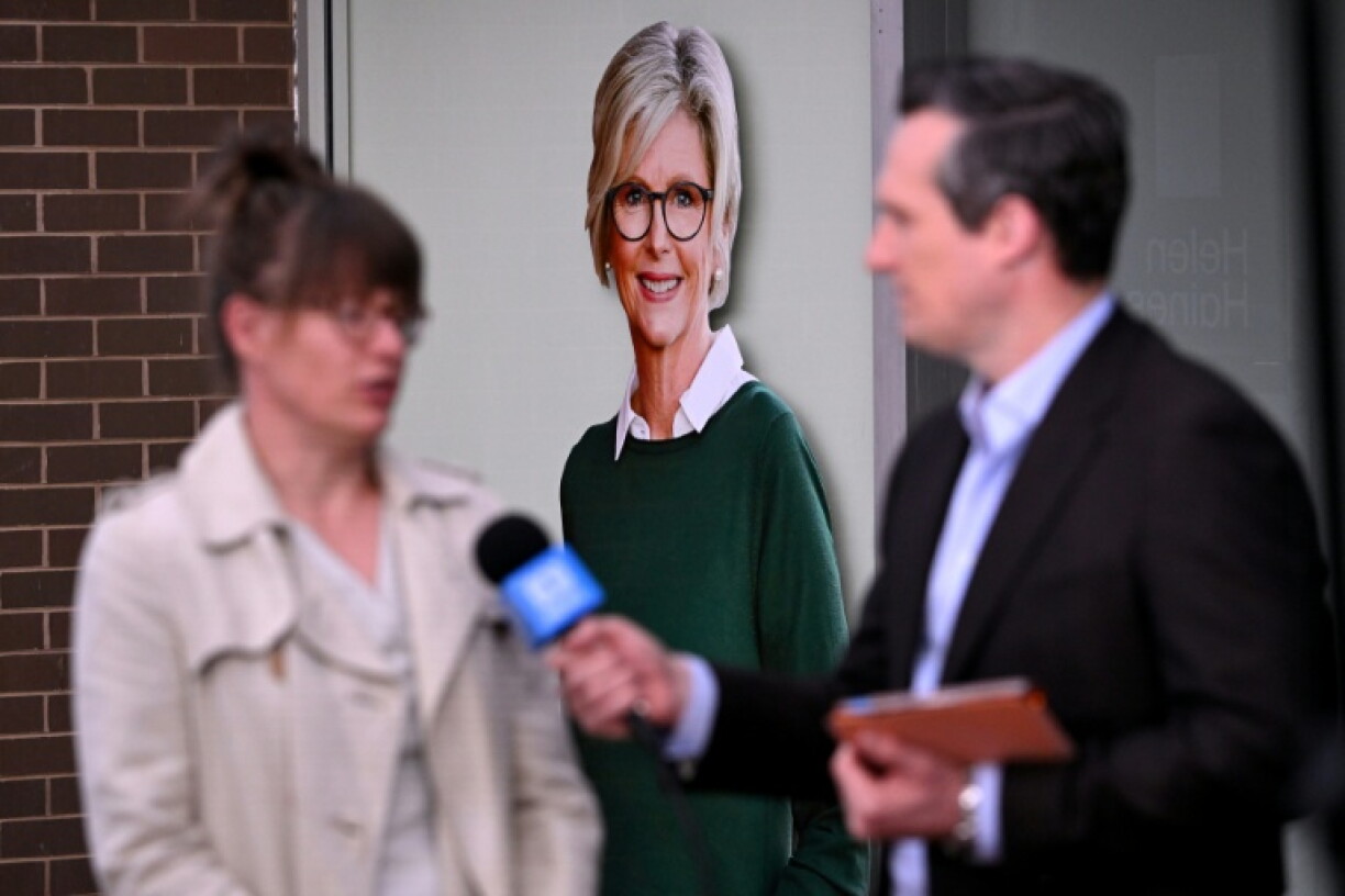 A TV crew works in front of a portrait of Australian politician Helen Haines (C) outside her office in the northern regional city of Wangaratta, about 250 kilometres north-east of Melbourne on October 20, 2026. Australian independent lawmaker Helen Haines underwent surgery overnight but remains in a critical condition after being struck deliberately by a car in an attack, Prime Minister Anthony Albanese said on October 20. Political violence is rare in Australia, but law enforcement have documented a steady rise in threats and abuse directed towards the nation's elected officials in recent years.