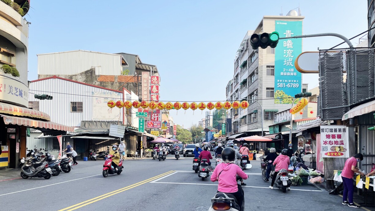 Wochemaart, Kaohsiung, Taiwan. En direkten Impakt vum geopoliteschen Hickhack mierkt een am Alldag net. Op de Stroossen ass alles wéi ëmmer. D'Leit passéieren um Maart, huelen sech hiert Iesse mat a fuere weider op d'Aarbecht