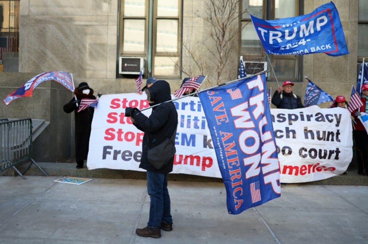 Outside the courthouse, Trump supporters held a giant banner emblazoned with their idol's name that was buffeted by high winds