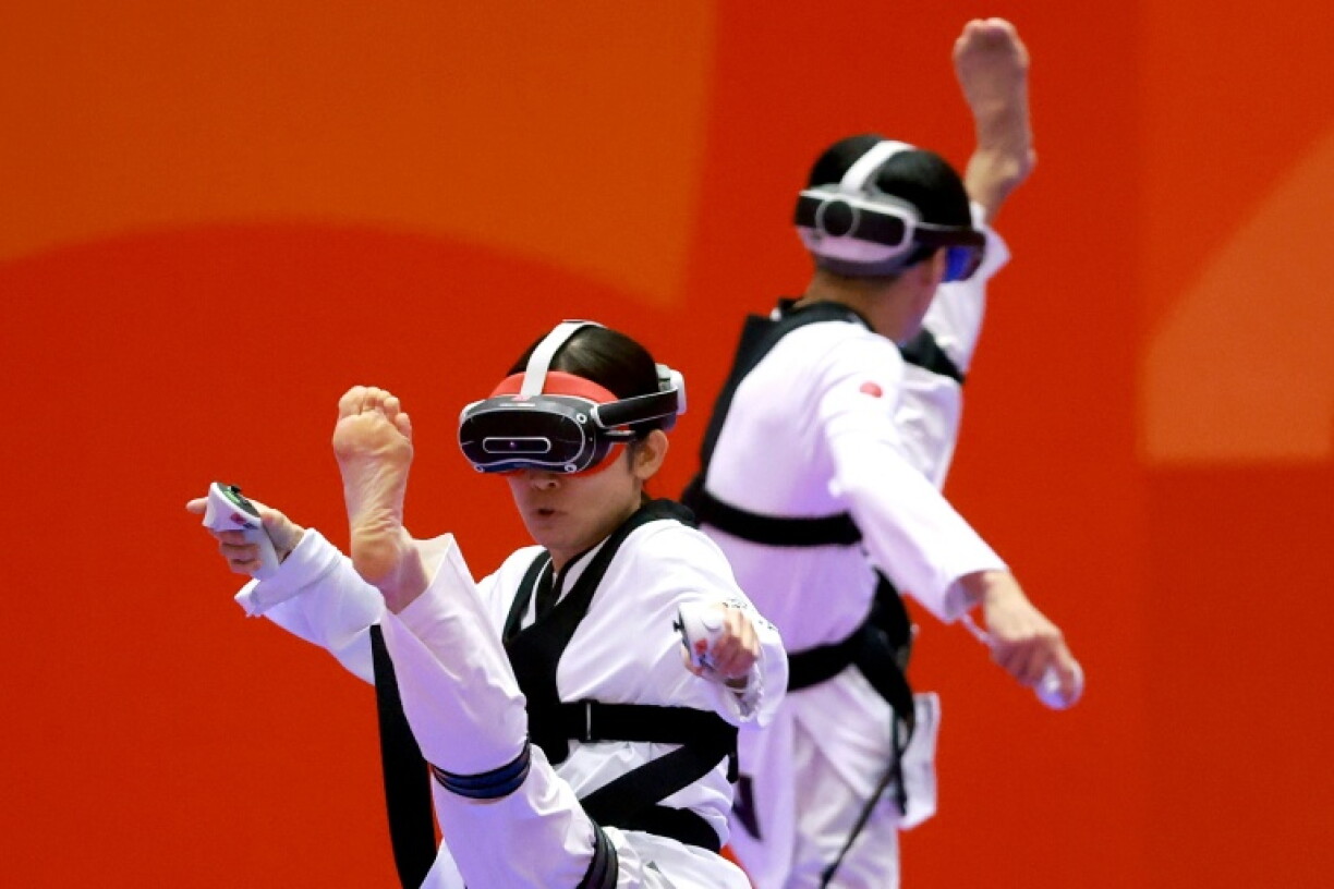 Japan’s Nakajima Miho (L) competes against compatriot Suzuki Hayate (R) in the mixed individual virtual taekwondo
