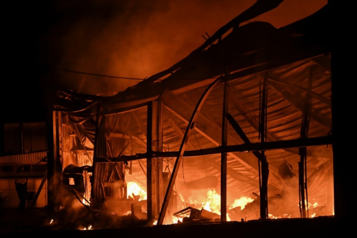 Firefighters battle flames at the site of a Russian drone strike on Kharkiv, in northeastern Ukraine