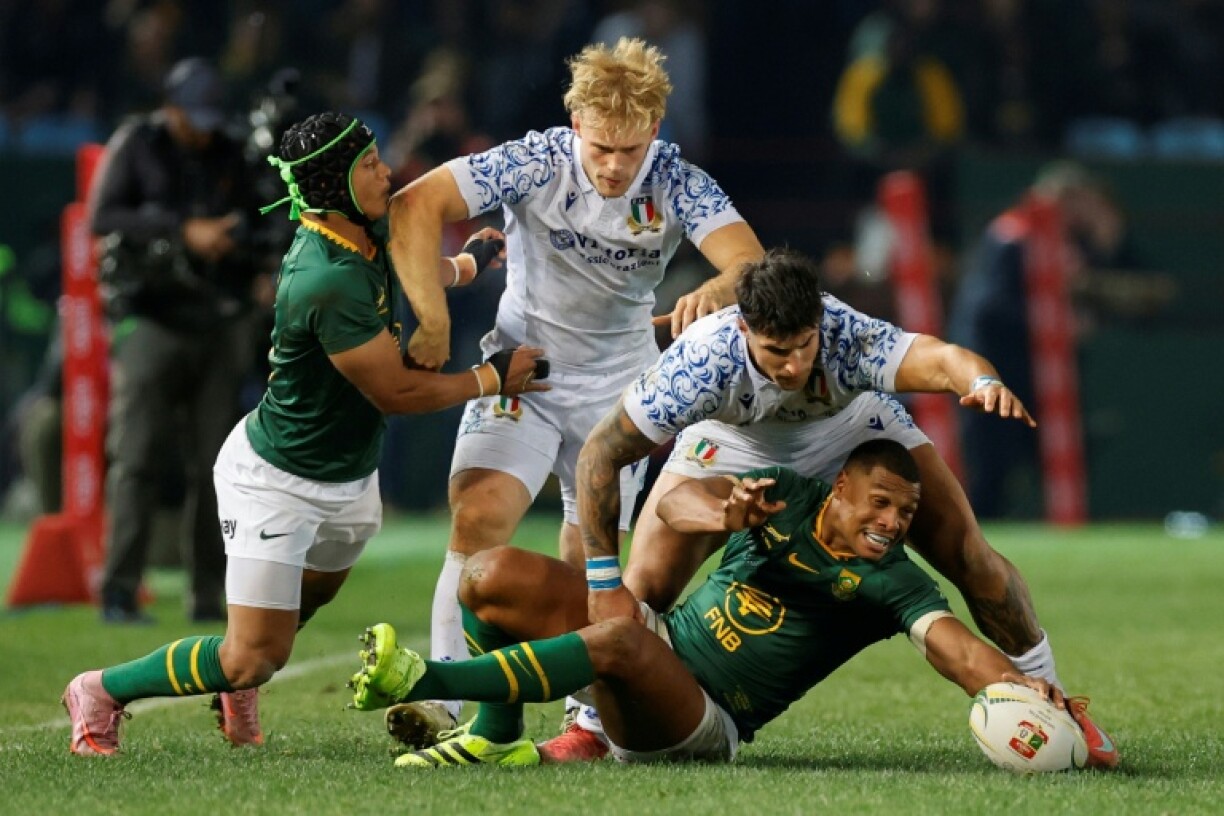 South Africa full-back Damian Willemse (R) under pressure from Italy centre Tommaso Menoncello (2nd R) in Pretoria.