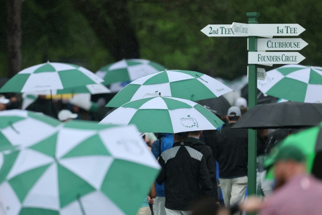 Spectators evacuate Augusta National Golf Club after bad weather halted the first official practice round for the 89th Masters