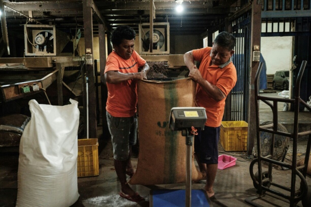 Workers weigh a sack of cloves after sifting and removing impurities at a warehouse in Ternate, North Maluku