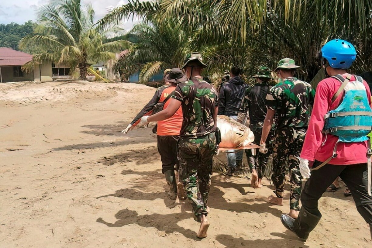 Indonesia's military and rescue personnel carrying the body of a flood victim in Batangtoru, South Tapanuli, North Sumatra