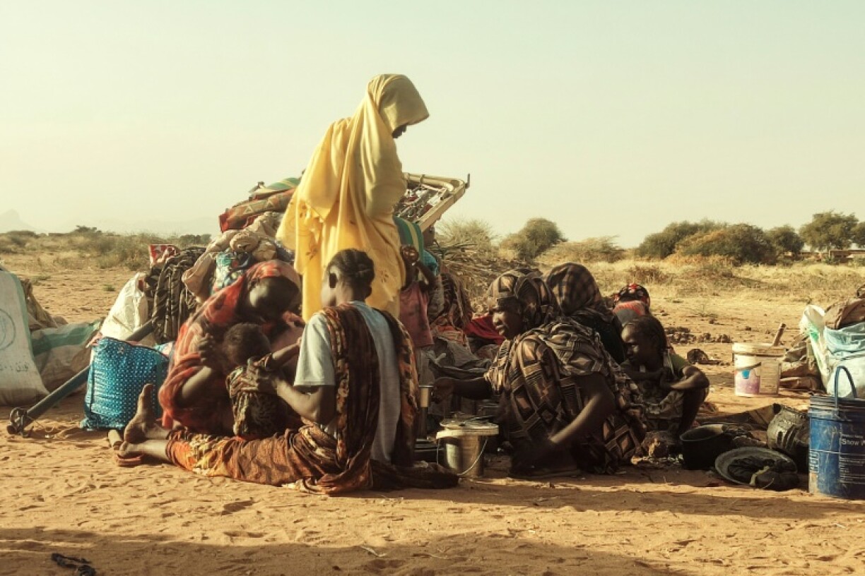 Sudanese women and children, who fled Zamzam camp, gather near the town of Tawila in North Darfur