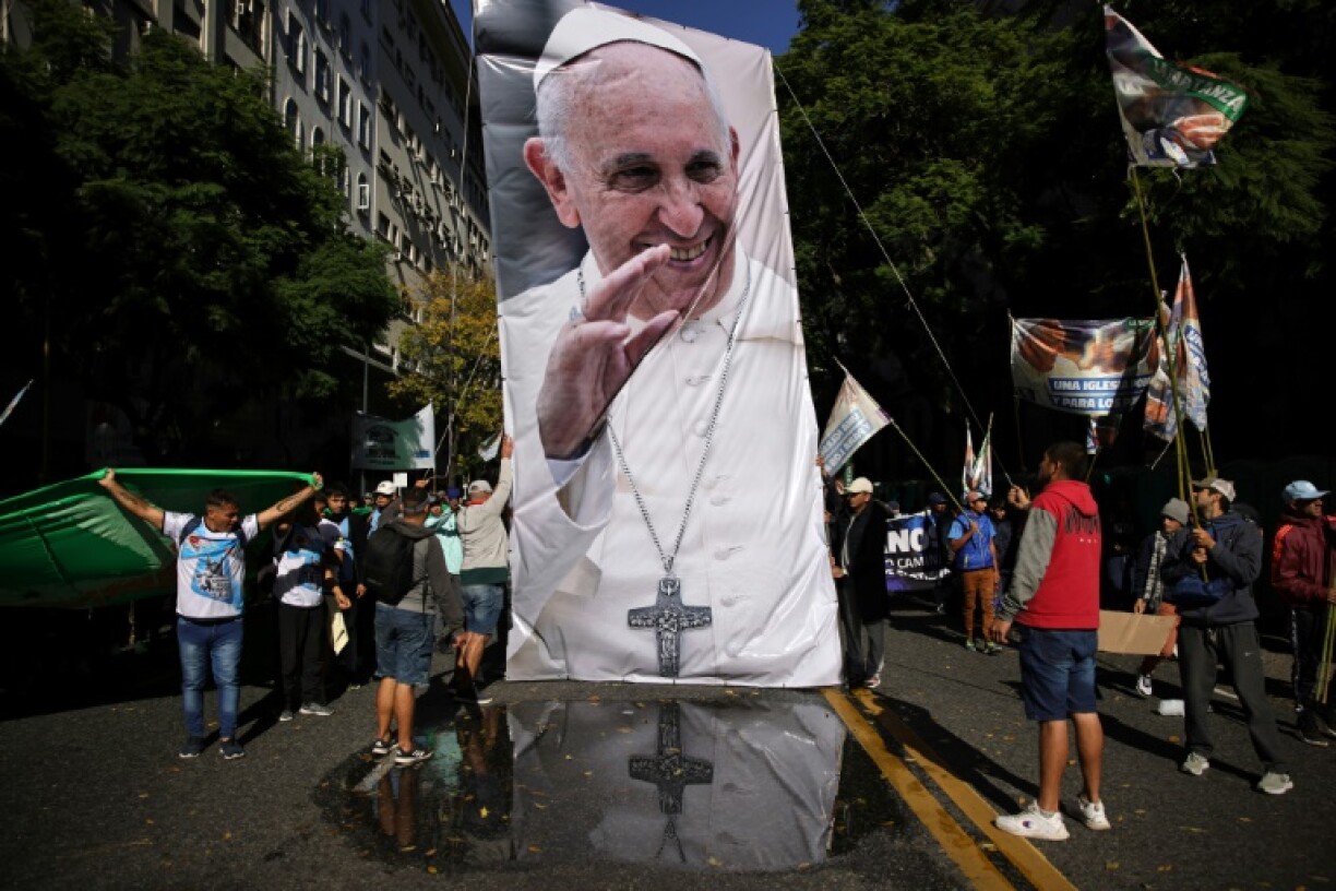 People walk with a giant image of Pope Francis near the Buenos Aires Cathedral