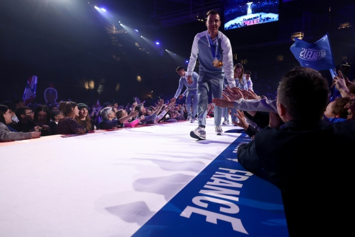 Quentin Fillon Maillet tape les mains des supporters en montant sur la scène, lors de la cérémonie pour fêter les athlètes français de retour des Jeux olympiques de Milan Cortina, le 23 février 2026 à Albertville