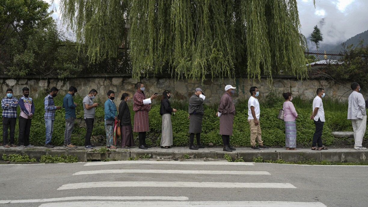 People queue up to register themselves and get inoculated with the Covid-19 coronavirus vaccine at a temporary vaccination centre in Thimpu on July 20, 2021.