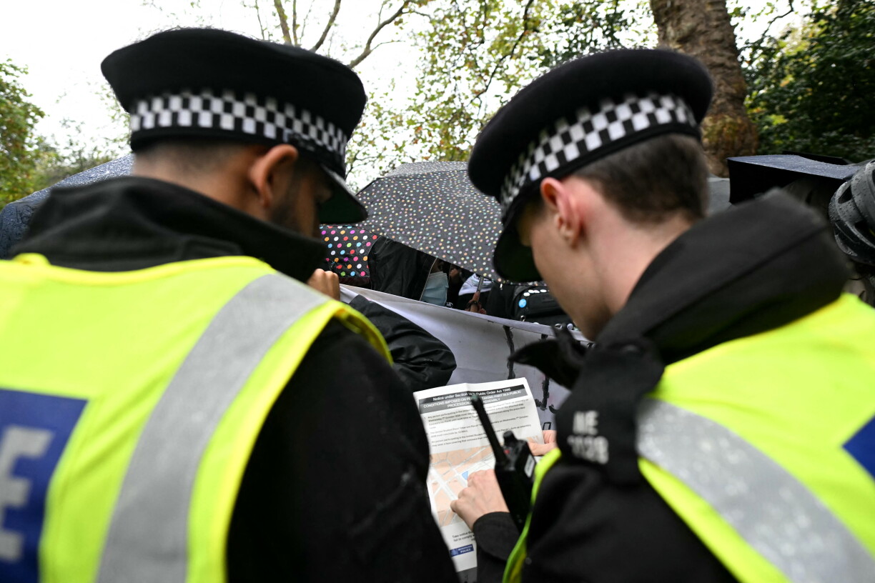 Police look at a document as people take part in an anti-Israel, pro-Palestine march in central London on October 7, 2026, on the third anniversary of the Hamas attacks on Israel. (Photo by JUSTIN TALLIS / AFP)