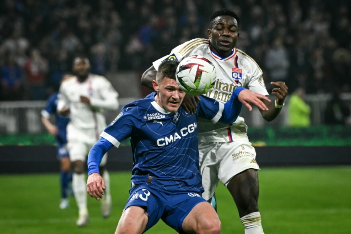 Le défenseur marseillais Quentin Merlin (g) à la lutte avec le Lyonnais Ernest Nuamah, le 4 février 2024 à Décines-Charpieu
