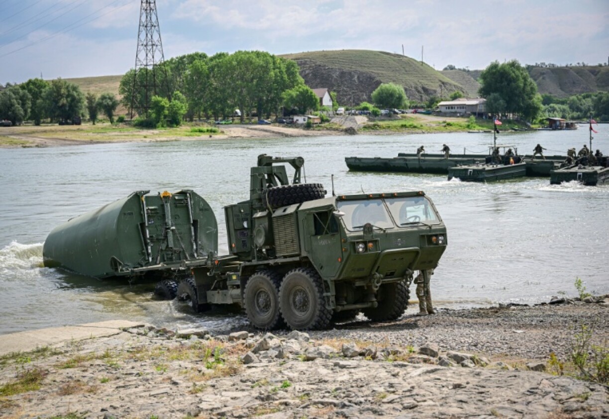 US soldiers install a floating element used to assemble a transportation barge across the Danube river on June 13, 2025
