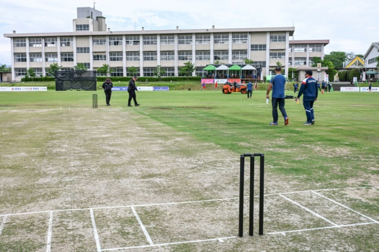 Cricket officials check the pitch prior to a women's international match in Sano, Japan