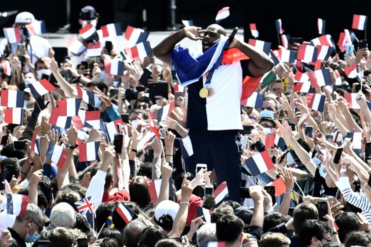 Teddy Riner entouré de supporters avec des drapeaux français au Trocadéro le 8 août 2021 à Paris