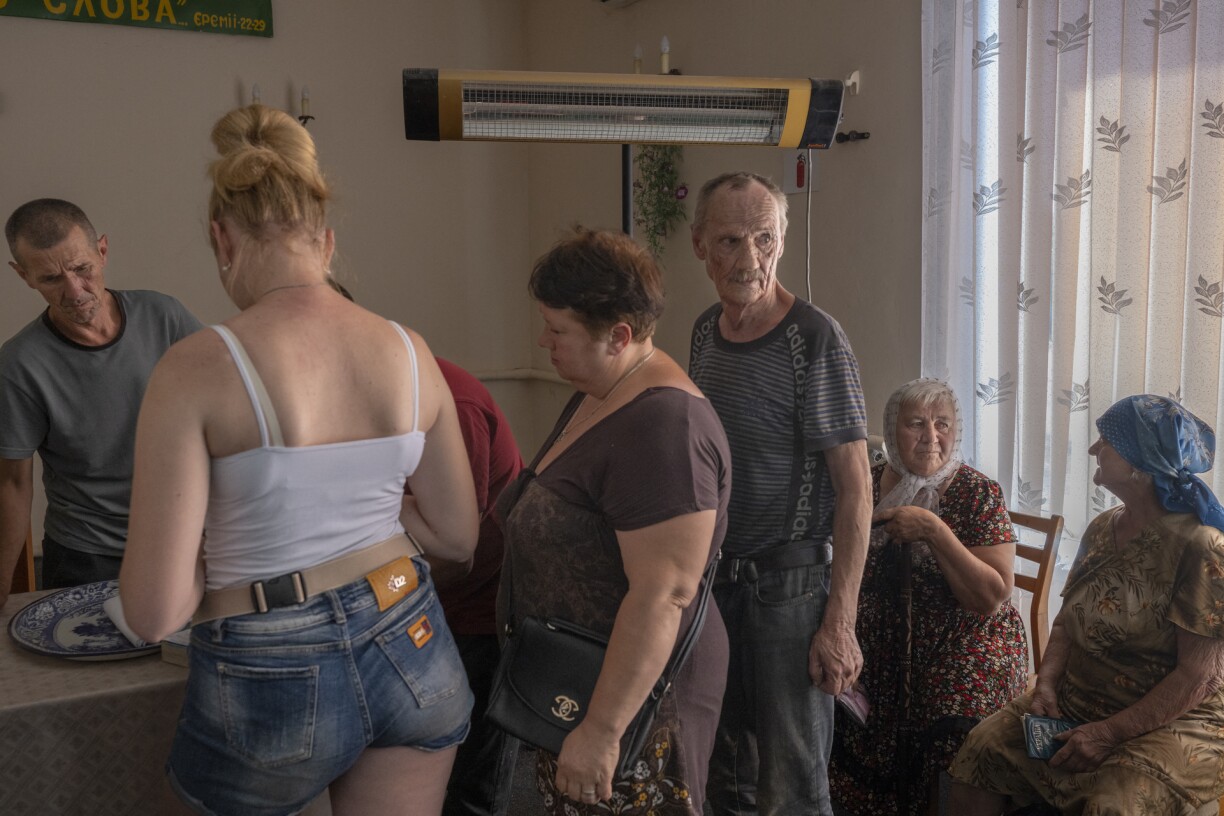Ukranian villagers wait for food aid in a church in the eastern Ukrainian Donbas region, on August 8, 2022, amid Russia's military invasion launched on Ukraine.