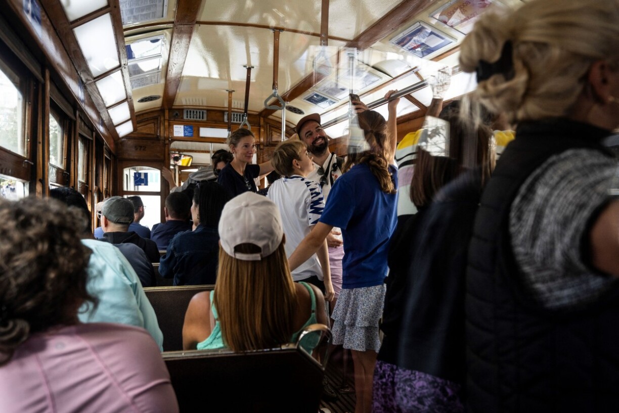 Des touristes en train de se prendre en selfie dans le tram historique de Lisbonne.