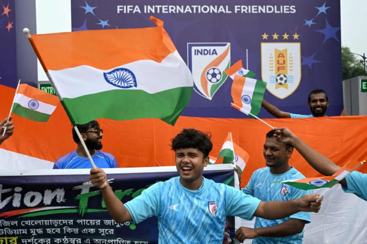 Fans wave India's national flag near the Salt Lake Stadium in Kolkata on October 3, 2026, before the start of the international friendly football match between India and Brazil.
