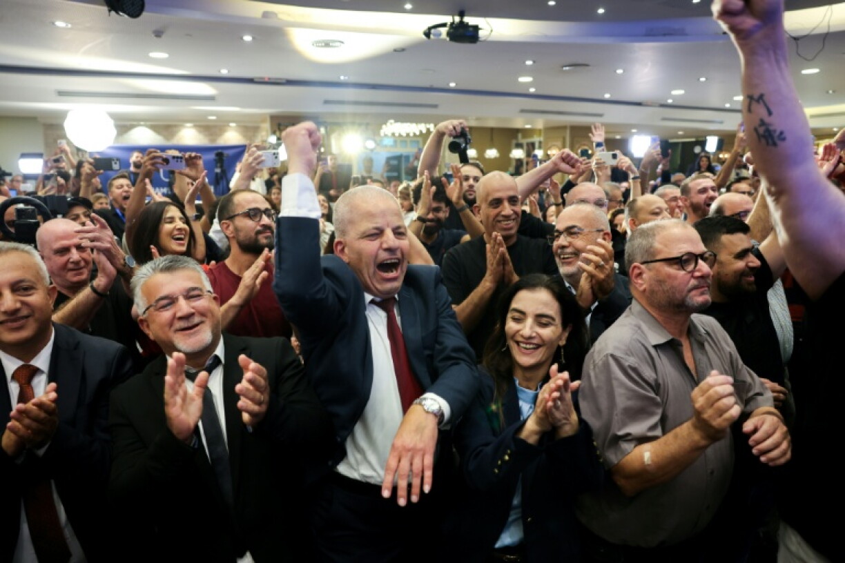 Yousef Jabareen, leader of Israel's Arab-led Joint List political alliance, (Centre-L) and other members cheer at the alliance's campaign headquarters in the northern Israeli city of Nazareth on October 27, 2026, as the first exit polls are announced on television during Israel's legislative election.