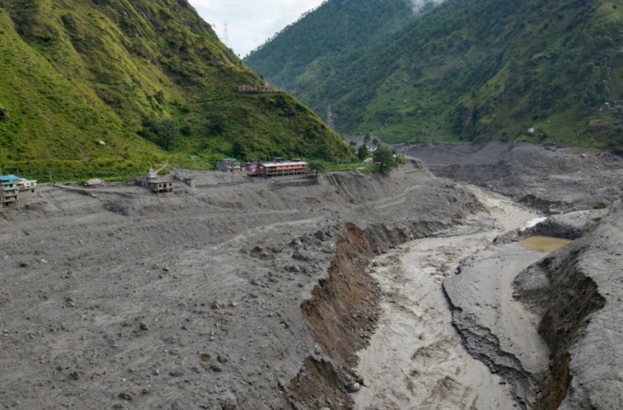 Vue aérienne d'un torrent d'eau boueuse déferlant près des habitations après des crues soudaines, près de la frontière entre le Népal et la Chine, au niveau du village de Syabrubesi, le 31 août 2026 au Népal