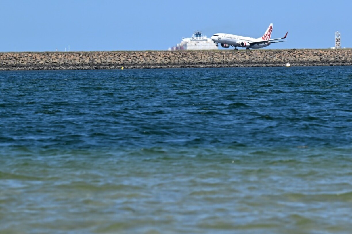 A Virgin Australia plane touches down at Sydney International Airport on February 27. Australia will let Qatar Airways buy a 25 percent stake in troubled Virgin Australia