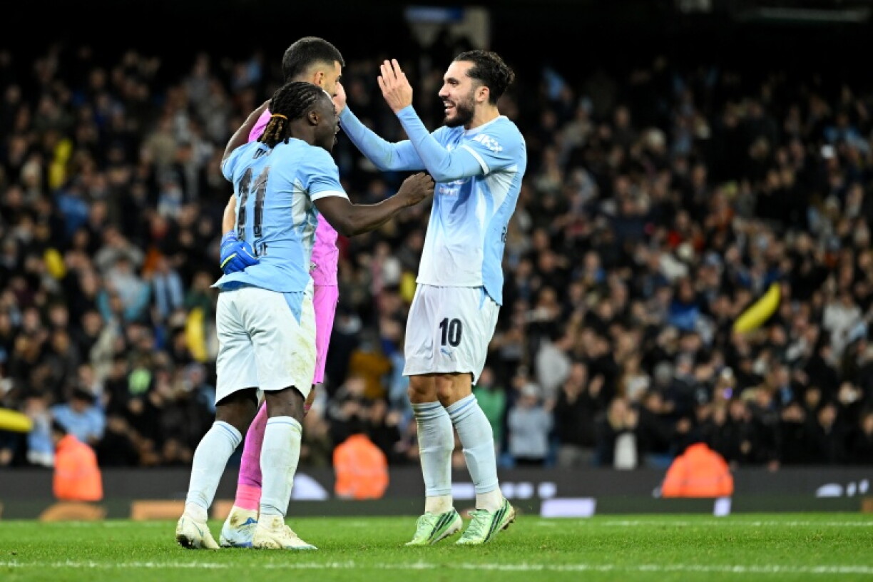 Les joueurs de Manchester City Rayan Cherki (à droite) et Jérémy Doku (à gauche) félicitent leur gardien Geronimo Rulli, après la victoire en Coupe de la ligue contre Brighton, aux tirs au but
