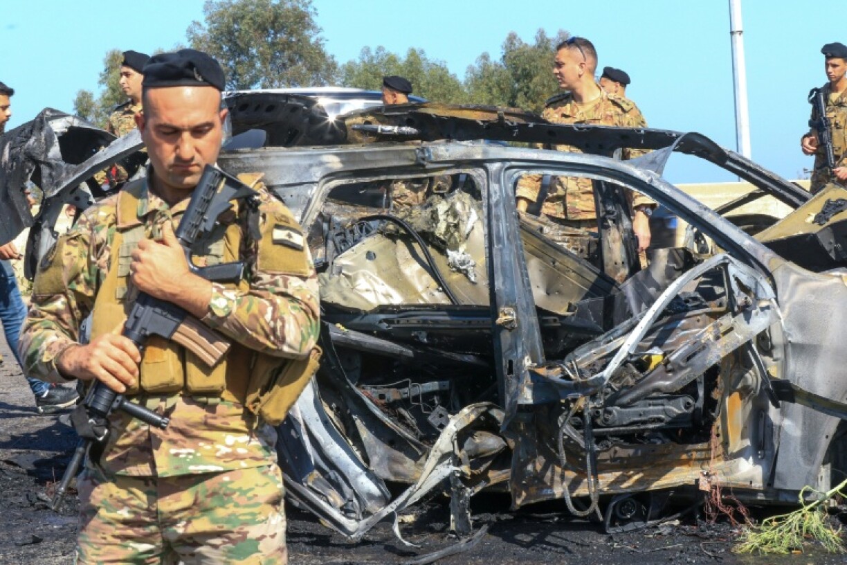 Lebanese soldiers at the site near a burnt-out vehicle in Ghaziyeh, near Sidon -- the health ministry said an Israeli strike killed one person