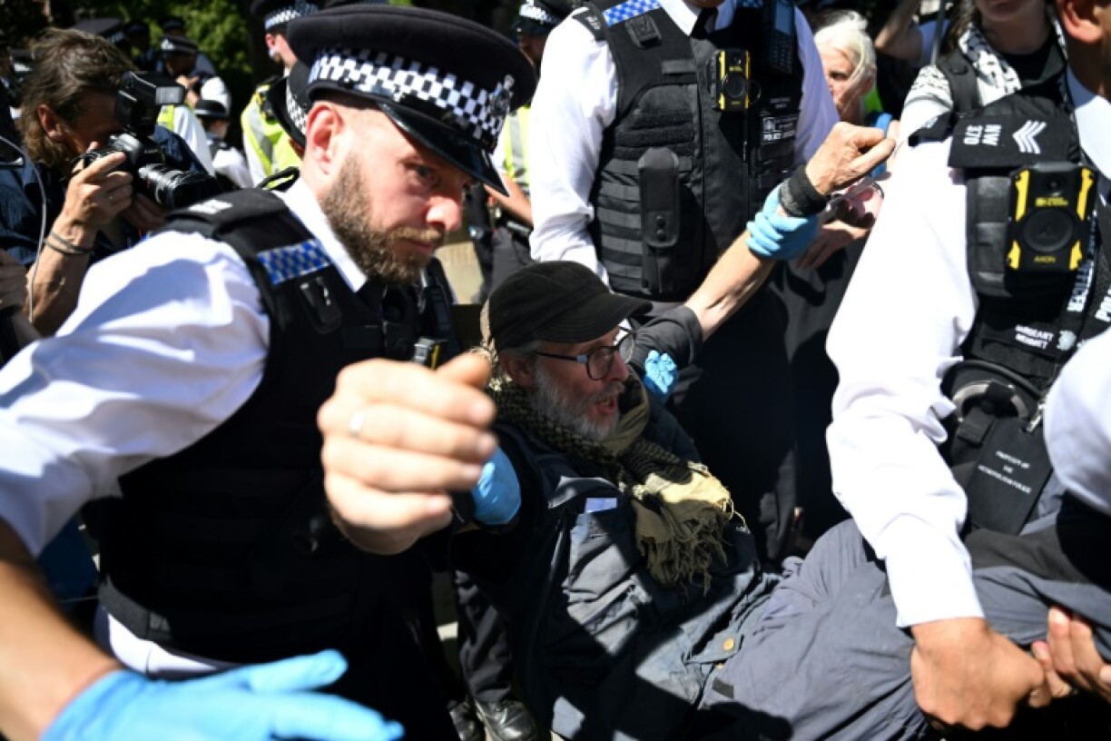 British police moving in on a small group of protesters displaying signs supporting Palestine Action