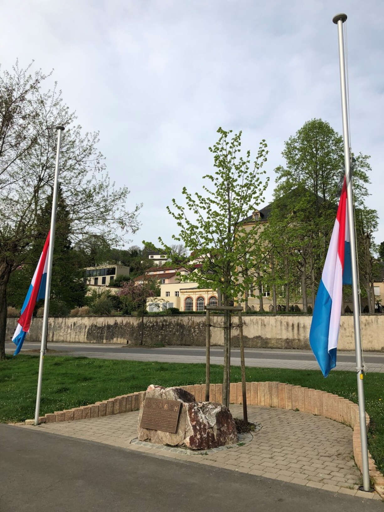 Och zu Schengen bei der Weilburger Lann an dem Gedenksteen 125 Joer Dynastie Lëtzebuerg Nassau hänken d'Fändelen op Hallefmast.