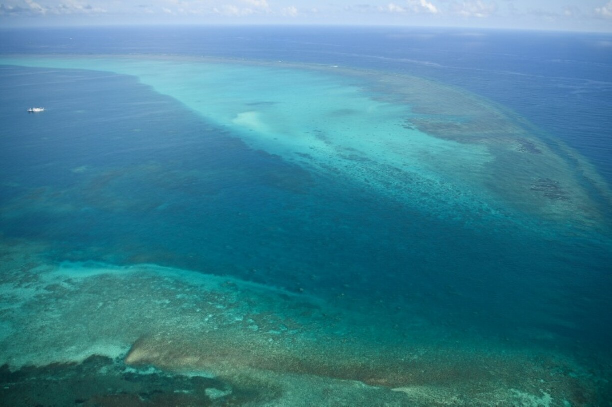 China Coast Guard vessels (top L) are seen anchored inside the lagoon of the Chinese-controlled Scarborough Shoal