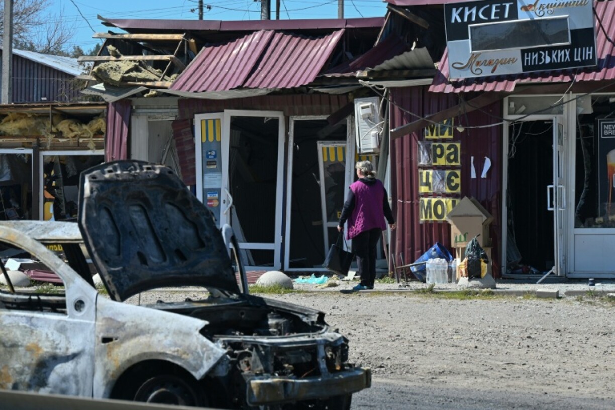 Une femme passe devant des magasins endommagés sur le site d’une frappe de missile russe dans la ville de Merefa, dans la région de Kharkiv, le 4 mai 2026