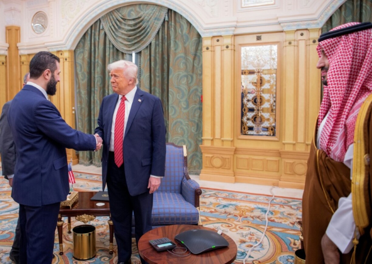 US President Donald Trump shakes hands with Syria's jihadist turned interim President Ahmed al-Sharaa as Saudi Crown Prince Mohammed bin Salman watches on.
