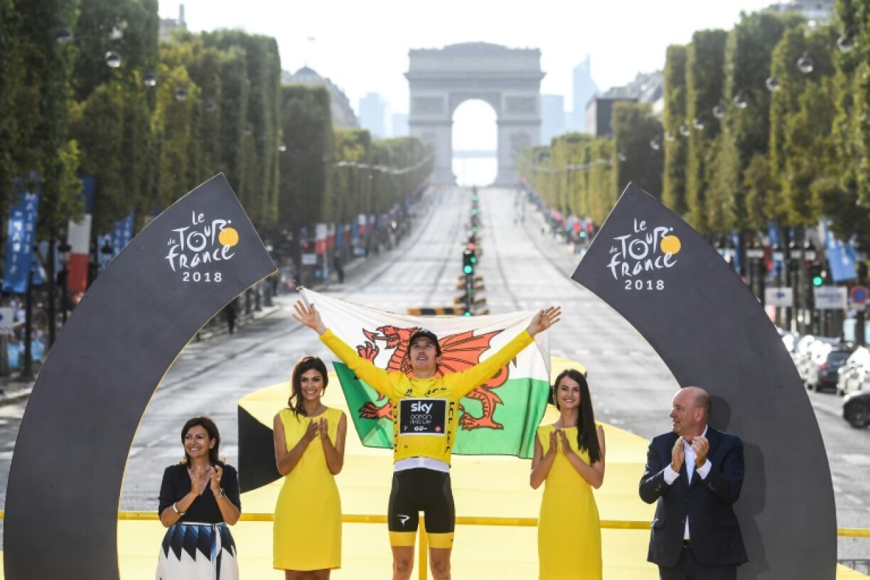 Geraint Thomas holds the Welsh flag aloft after his 2018 Tour de France triumph