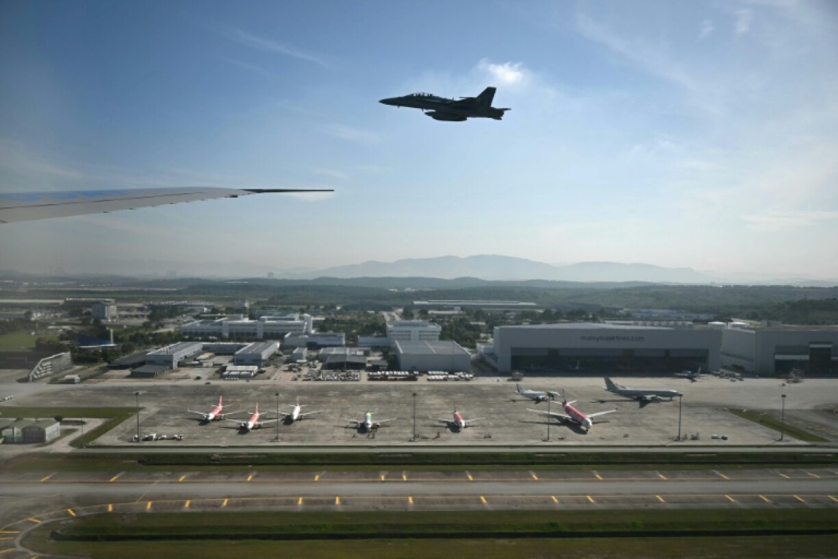 A Malaysian F-18 escort plane is seen from the cabin of Air Force One as it prepares to land at Kuala Lumpur
