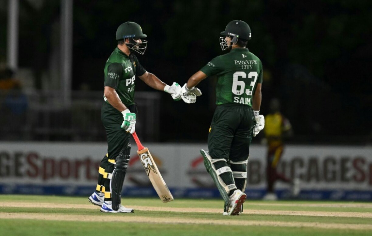 Pakistan's Sahibzada Farhan, left, and Saim Ayub, right, celebrate reaching 100 runs with their opening partnership in a T20I victory over the West Indies at Lauderhill, Florida