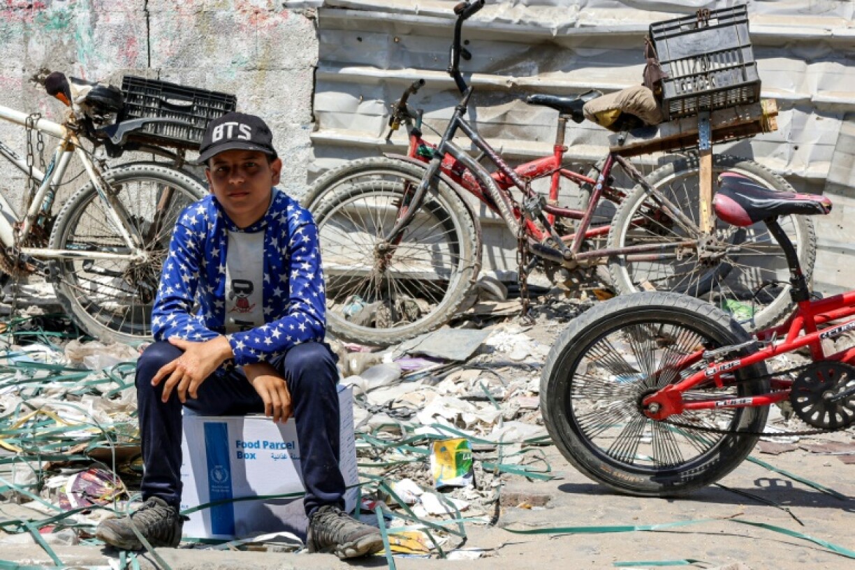 Un garçon est assis sur un paquet d'aide humanitaire fourni par l'agence de l'ONU pour les réfugiés palestiniens (Unrwa) dans le centre de la ville de Gaza le 27 août 2024