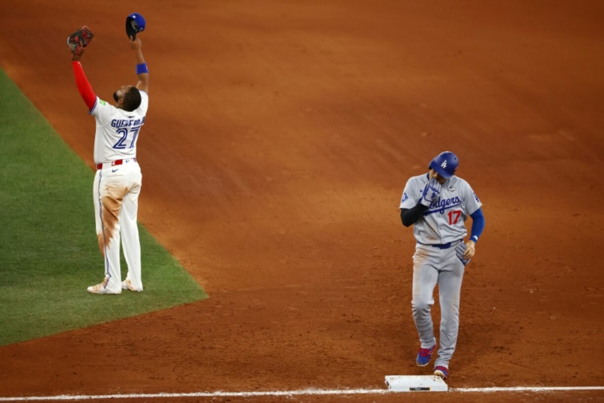 Toronto's Vladimir Guerrero Jr celebrates victory as Shohei Ohtani walks back to the dugout after game one of the World Series