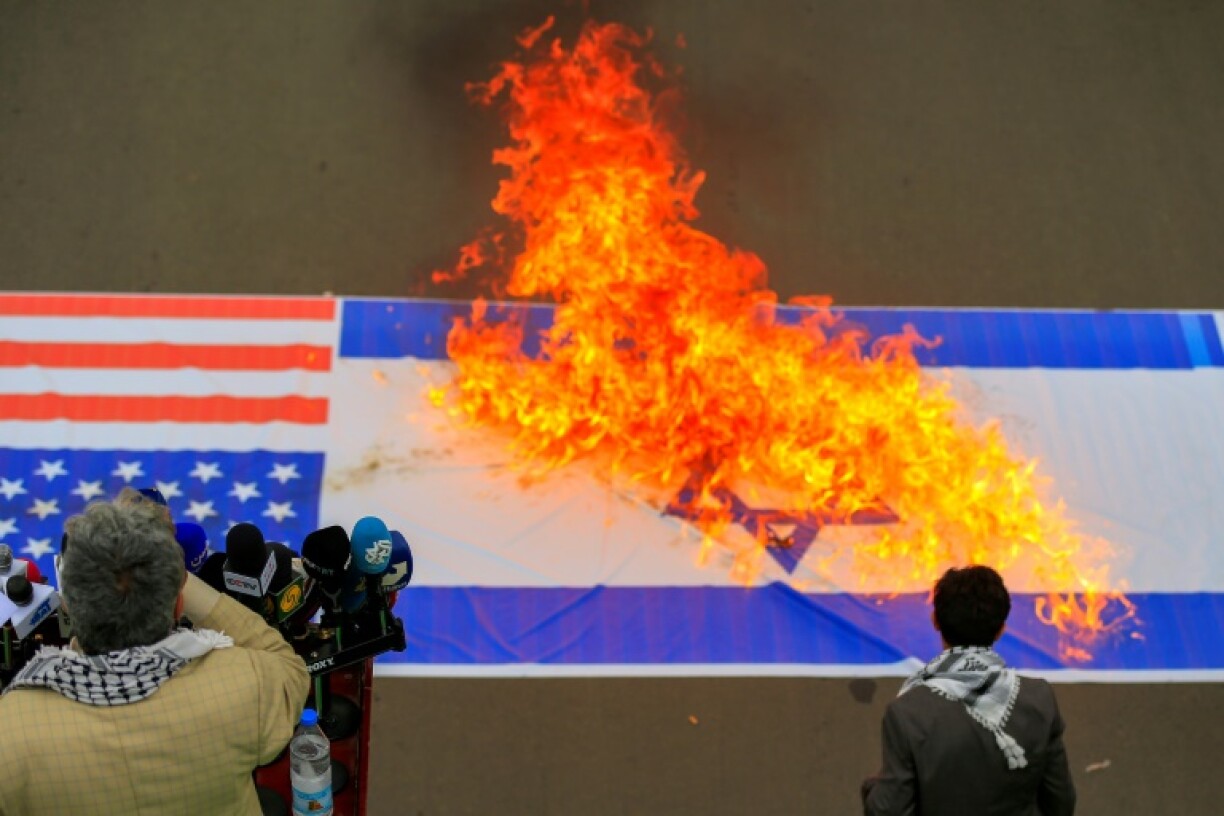 Demonstrators burn US and Israeli flags during a Sanaa rally in solidarity with Palestinians in the Gaza Strip