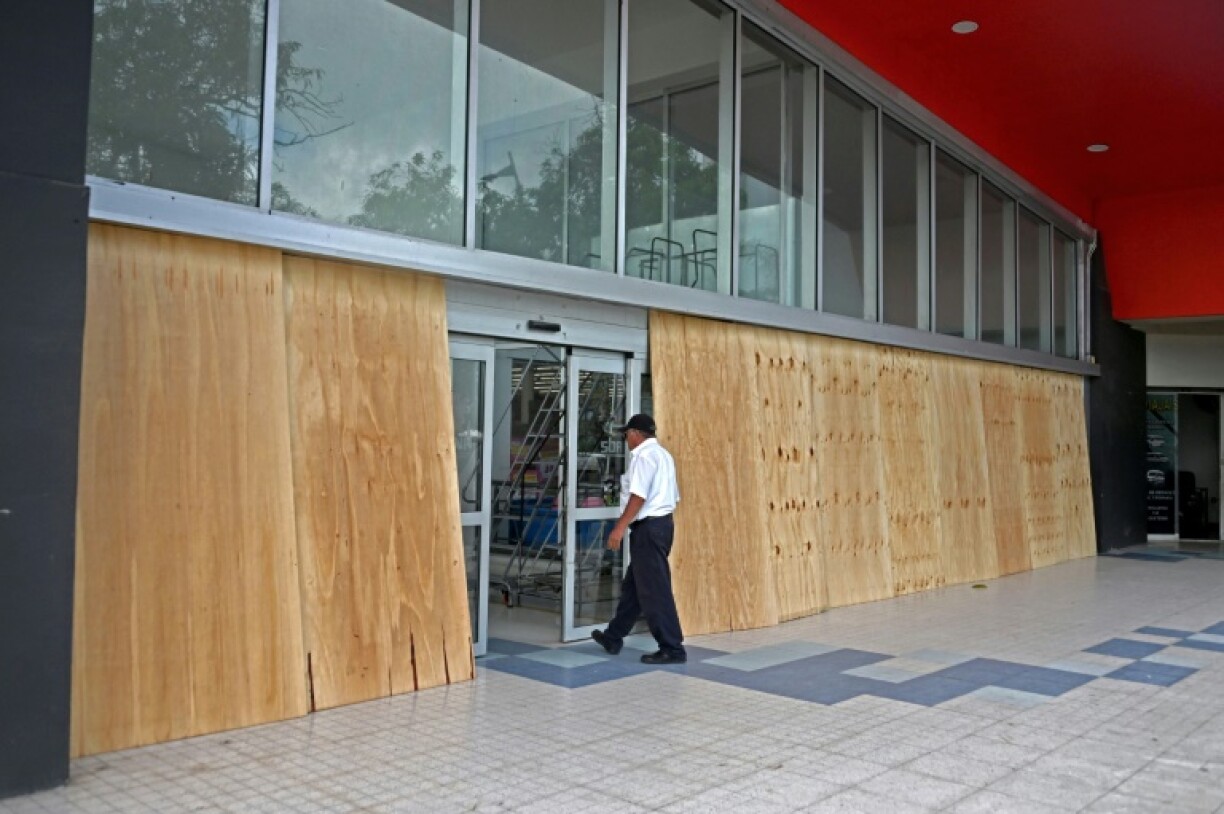 Des panneaux en bois installés devant les vitres d'une entreprise avant l'arrivée de l'ouragan Erick, le 18 juin 2025 à Acapulco, dans le sud du Mexique