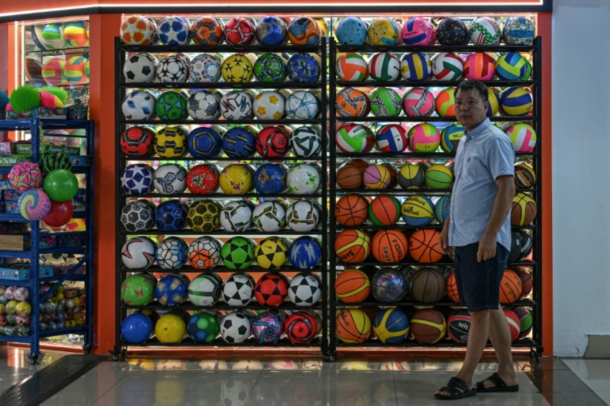 A man walks past a sporting goods store selling balls at the Yiwu International Trade Market in Yiwu, in eastern China's Zhejiang province on September 17, 2025