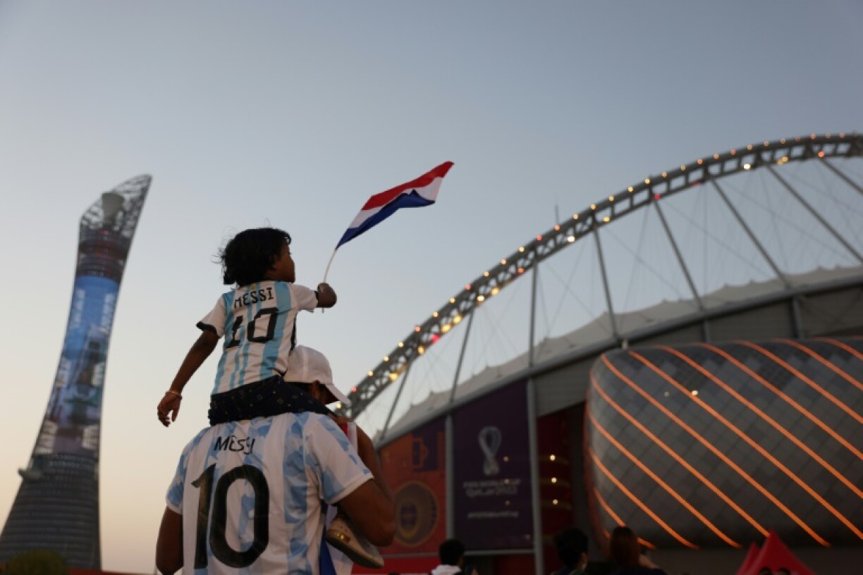 Un supporter de l'Argentine de Lionel Messi et son enfant devant un des stades du Mondial-2022, le 3 décembre 2022 à Doha