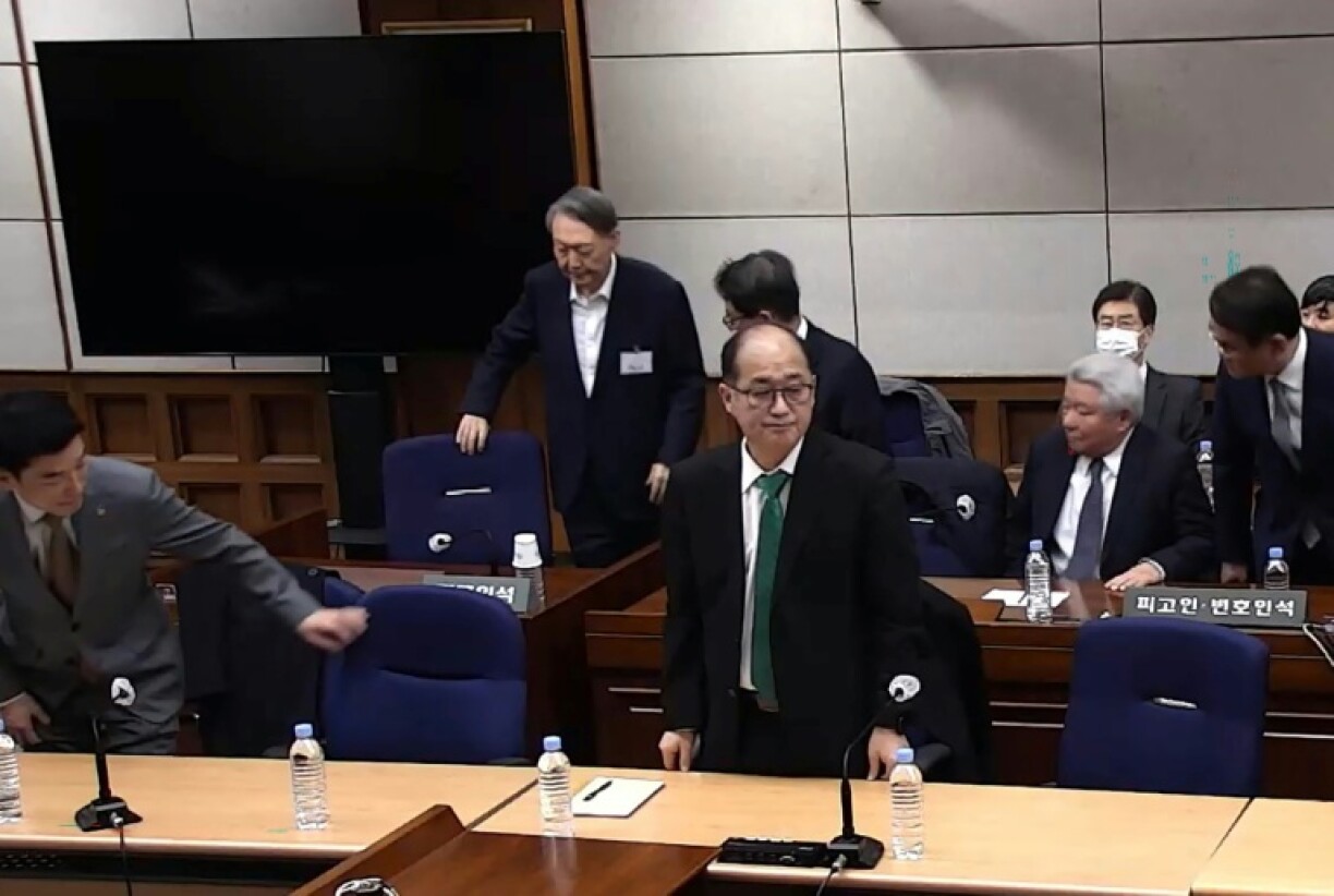 Cette capture d'écran tirée d'une vidéo distribuée par le tribunal central de Séoul et diffusée par l'agence Yonhap montre l'ancien président sud-coréen Yoon Suk Yeol (2e rangée, à gauche) assistant à un procès pour insurrection au tribunal central de Séoul, le 19 février 2026