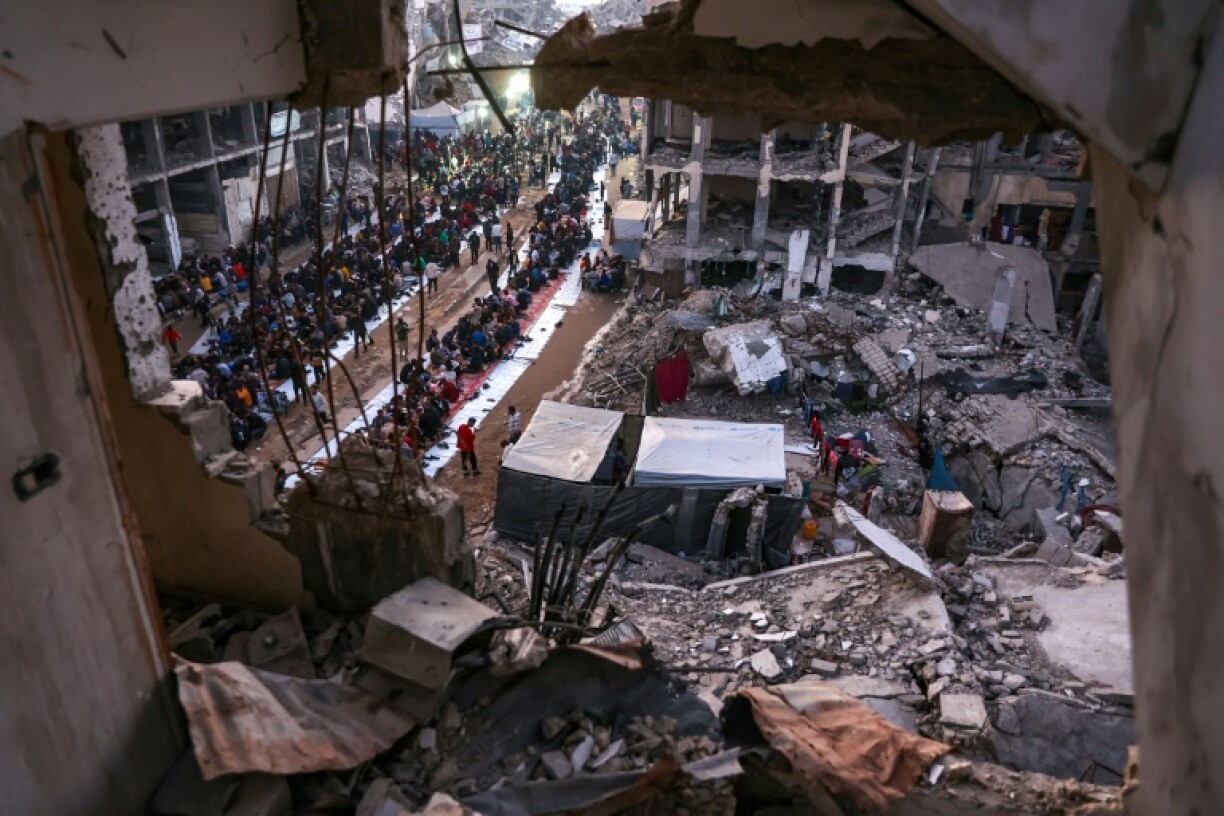Palestinians gather for a mass fast-breaking iftar meal amid the rubble of destroyed buildings in Beit Lahia, northern Gaza