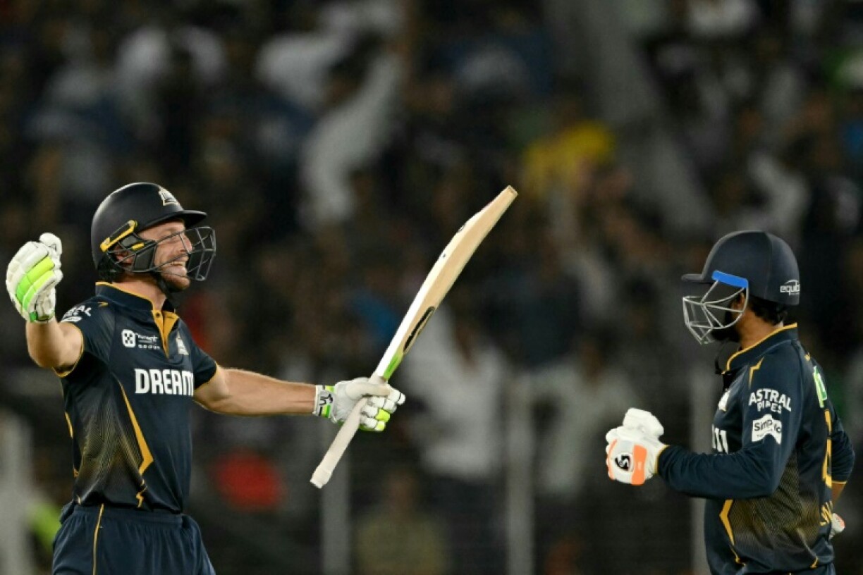 Jos Buttler (L) and Rahul Tewatia celebrate victory over Delhi Capitals that took Gujarat top of the IPL