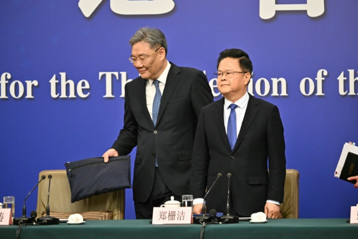 Zheng Shanjie (R), Chairman of National Development and Reform Commission of China, and Wang Wentao, China's Minister of Commerce, arrive to a press conference during the second session of the 14th National People's Congress (NPC) in Beijing on March 6, 2025.