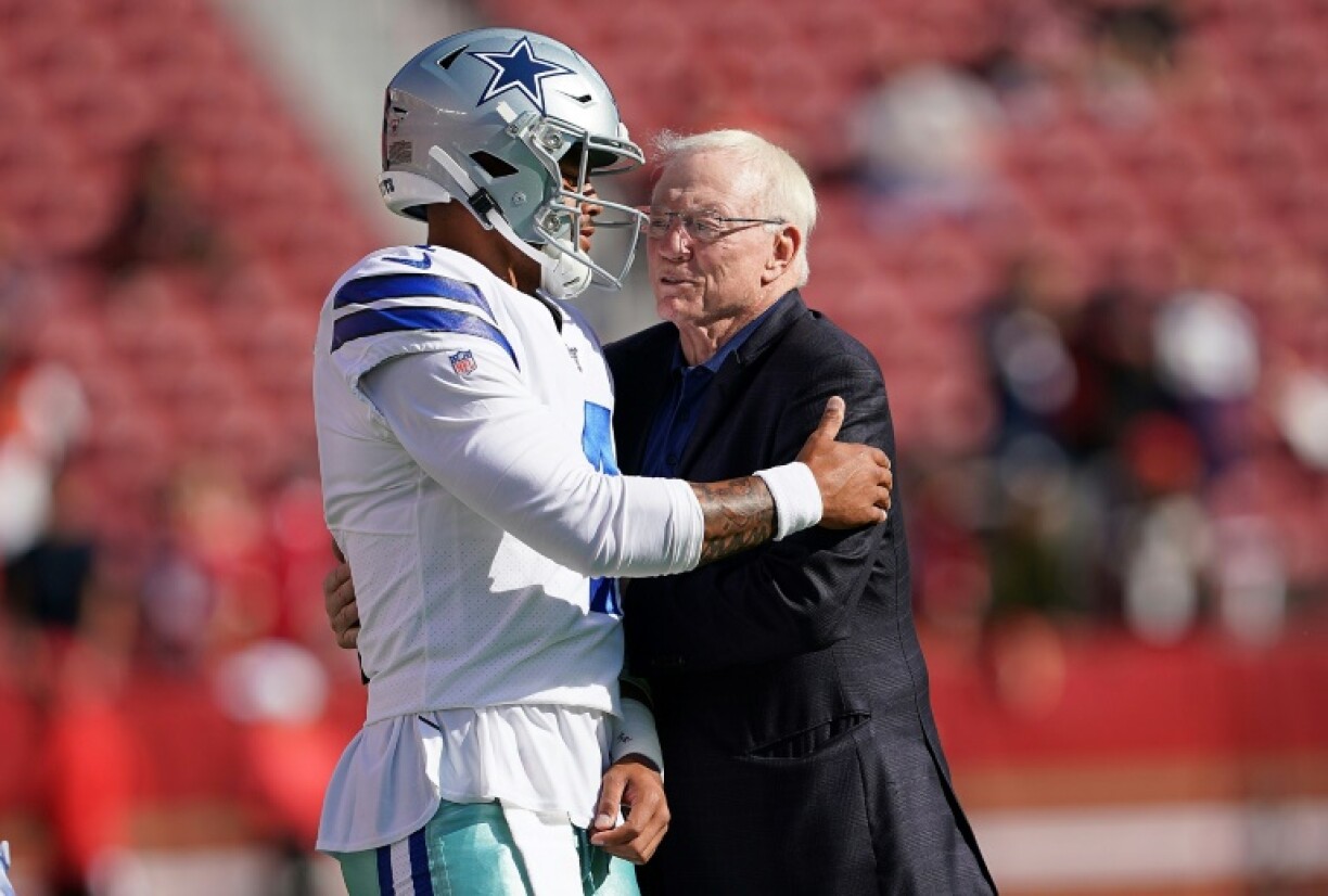 Dallas Cowboys quarterback Dak Prescott, left, hugs team owner Jerry Jones before an NFL game even as the club tries to embrace a season with a new coach and without star defender Micah Parsons