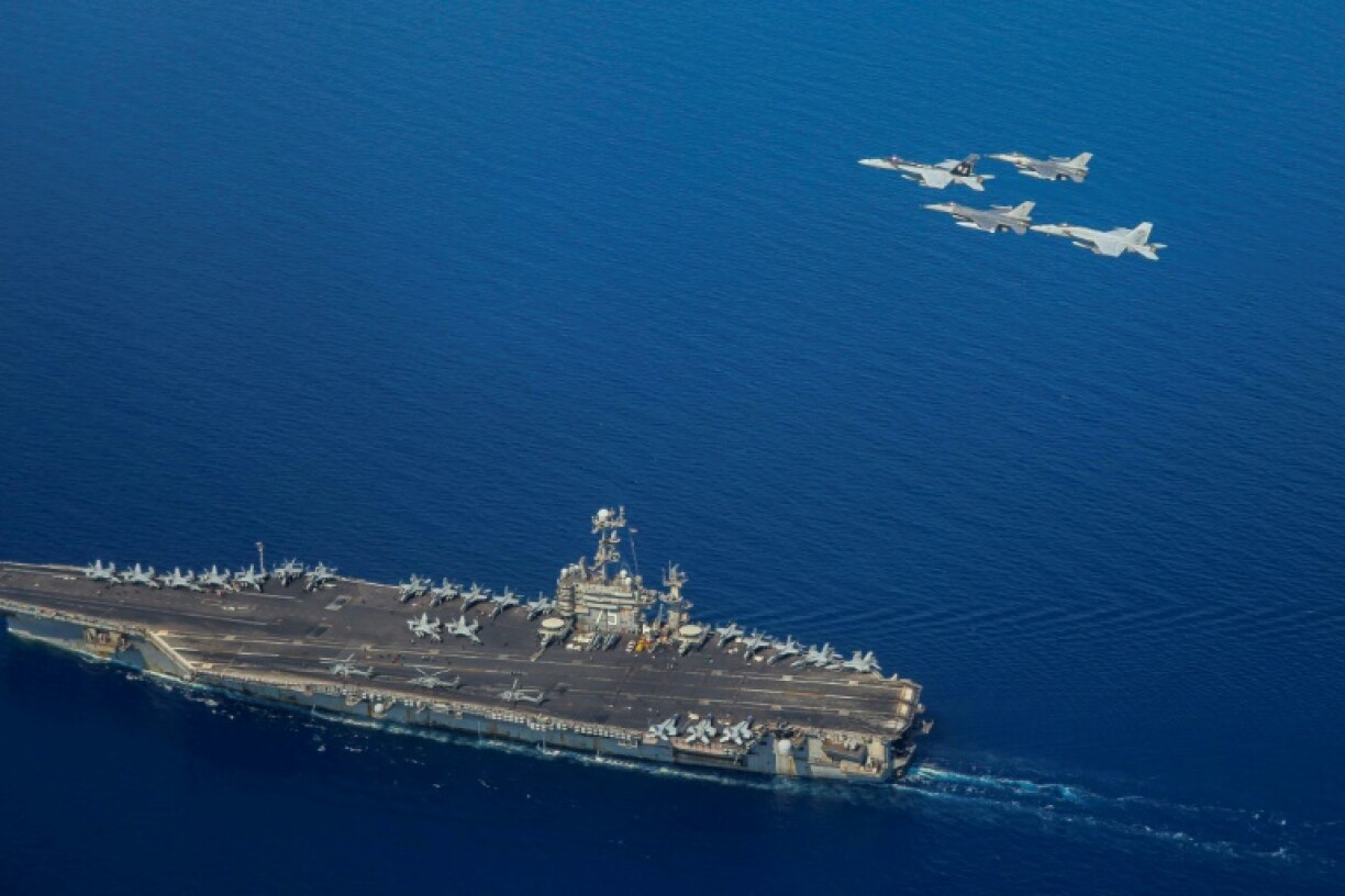 A handout file picture from the US Navy showing the USS Harry S Truman with F/A-18 and F-16 jets flying overhead