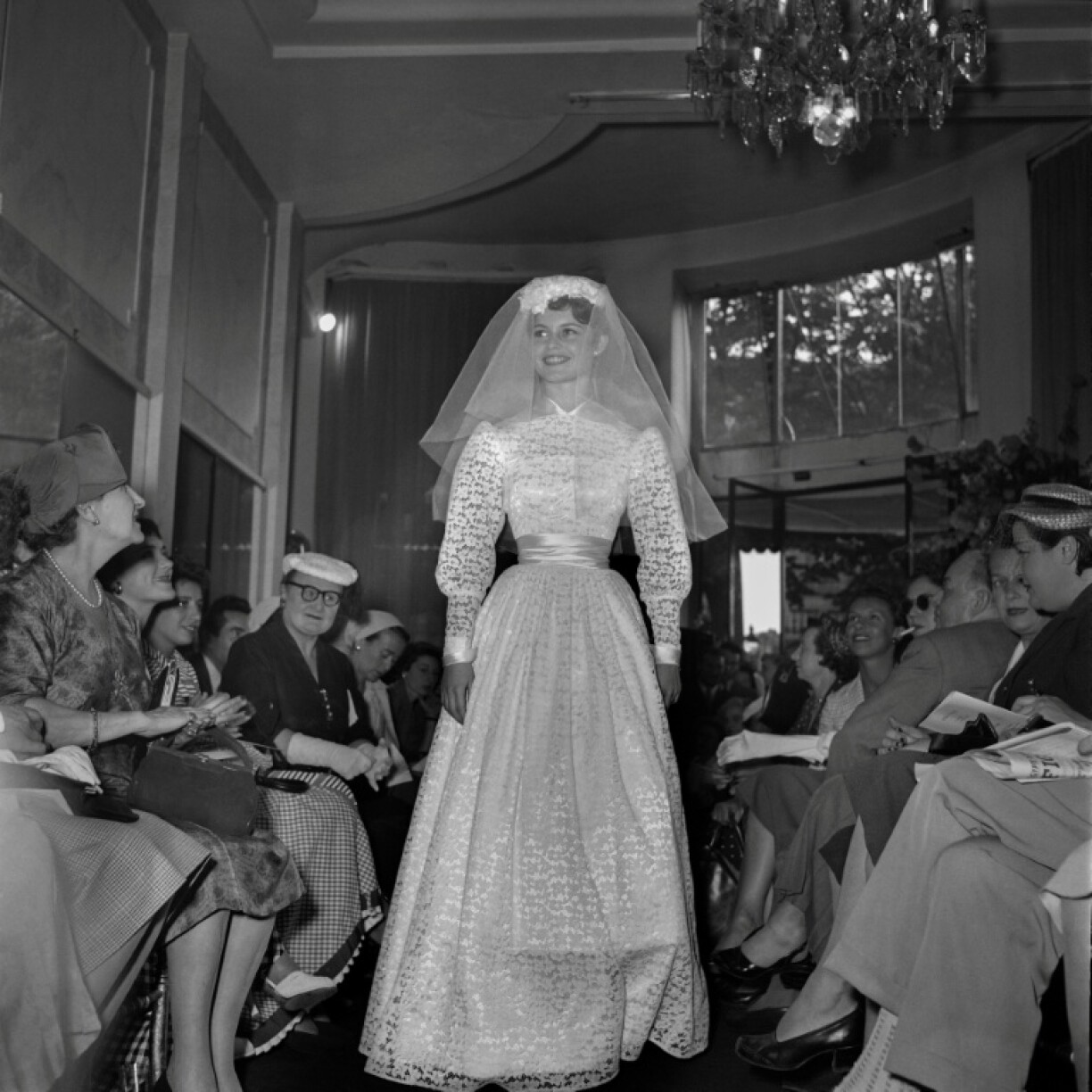 Brigitte Bardot présente une robe de mariée lors d'un défilé à Paris, le 25 juillet 1953