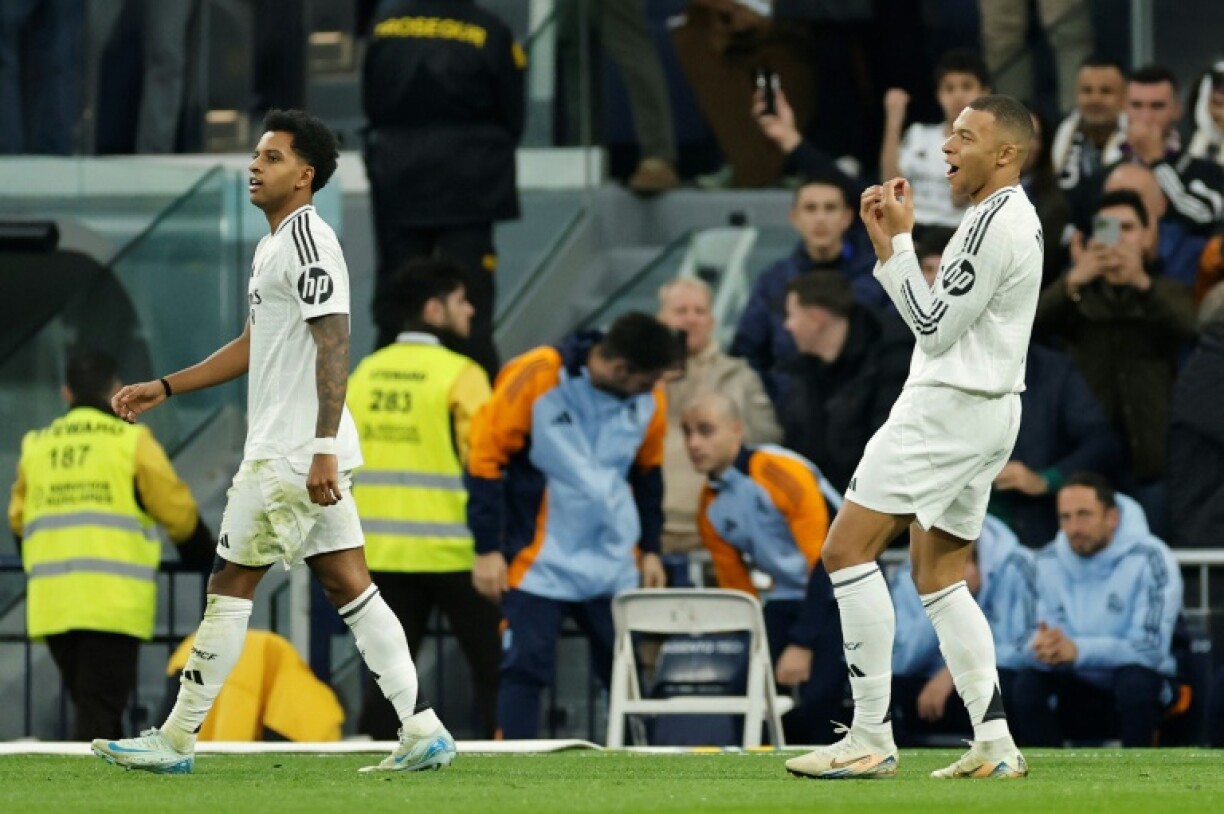 Real Madrid's French forward Kylian Mbappe (R) celebrates scoring the opening goal against Sevilla