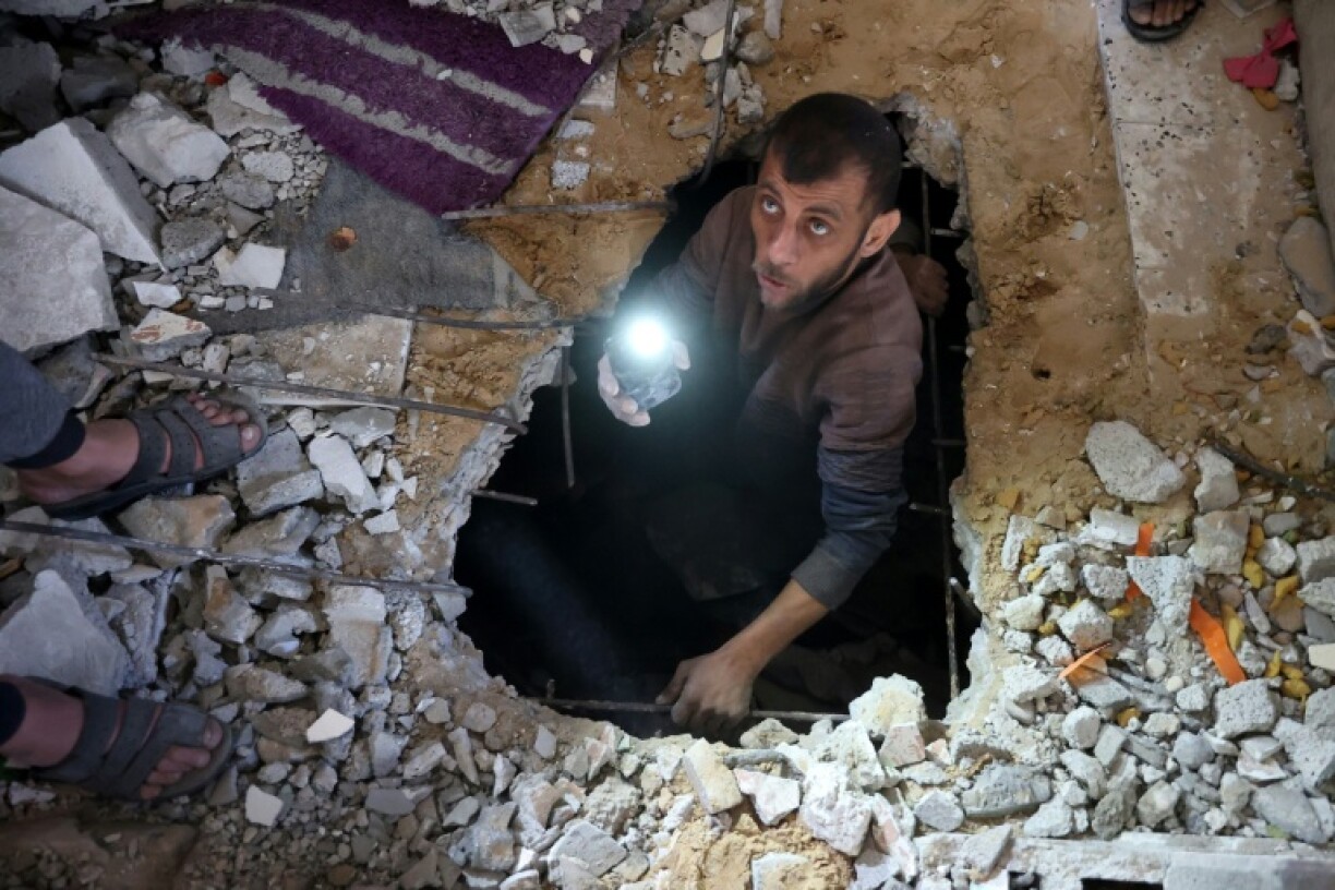 A man searches for victims or survivors amid the rubble of a house hit in a strike on Gaza City